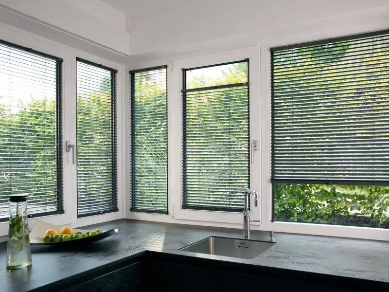 Aluminium-Jalousien in einer hellen Küche mit Eckfenstern